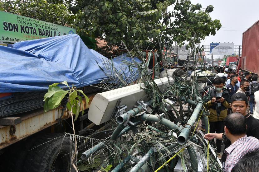 Warga melihat lokasi tempat kejadian kecelakaan sebuah truk kontainer yang menabrak halte bus di depan SDN Kota Baru II dan III di Jalan Sultan Agung, Bekasi, Jawa Barat, Rabu (31/8/2022). Pemkot Bekasi akan meliburkan sekolah terdampak kecelakaan selama beberapa hari ke depan. 