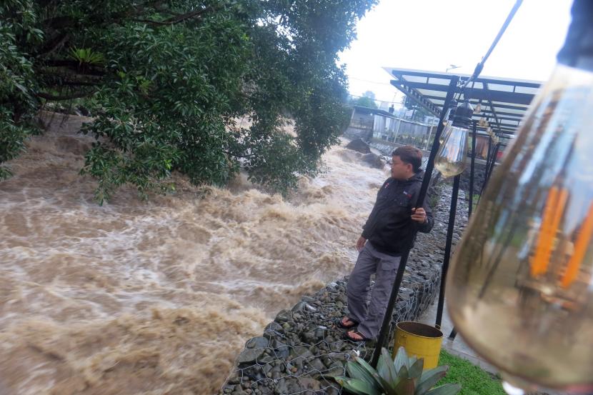 Warga melihat luapan Sungai Ciliwung di Cisarua, Kabupaten Bogor, Jawa Barat. Tingginya intensitas curah hujan di wilayah Puncak, Kabupaten Bogor menyebabkan naiknya ketinggian muka air di sepanjang aliran Sungai Ciliwung. (ilustrasi)