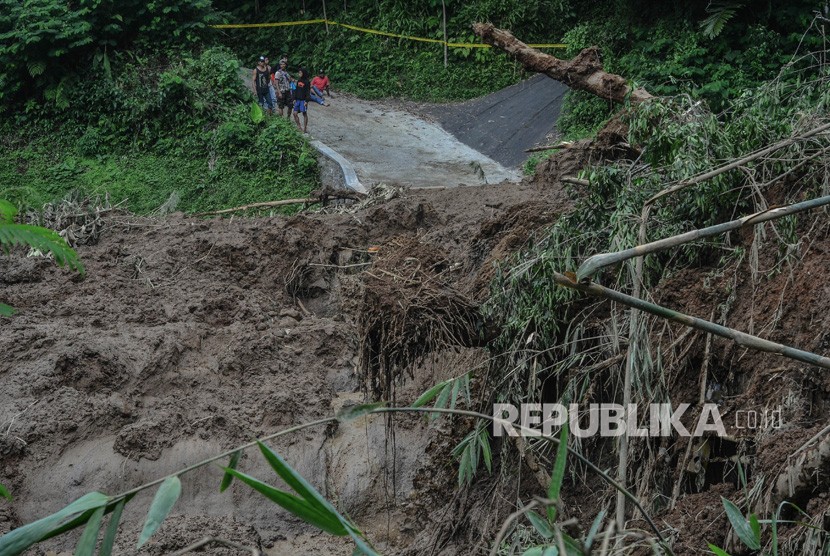 Warga melihat material tanah longsor yang menimbun jalan di Desa Santanamekar, Kecamatan Cisayong, Kabupaten Tasikmalaya, Jawa barat, Jumat (28/2/2020). 