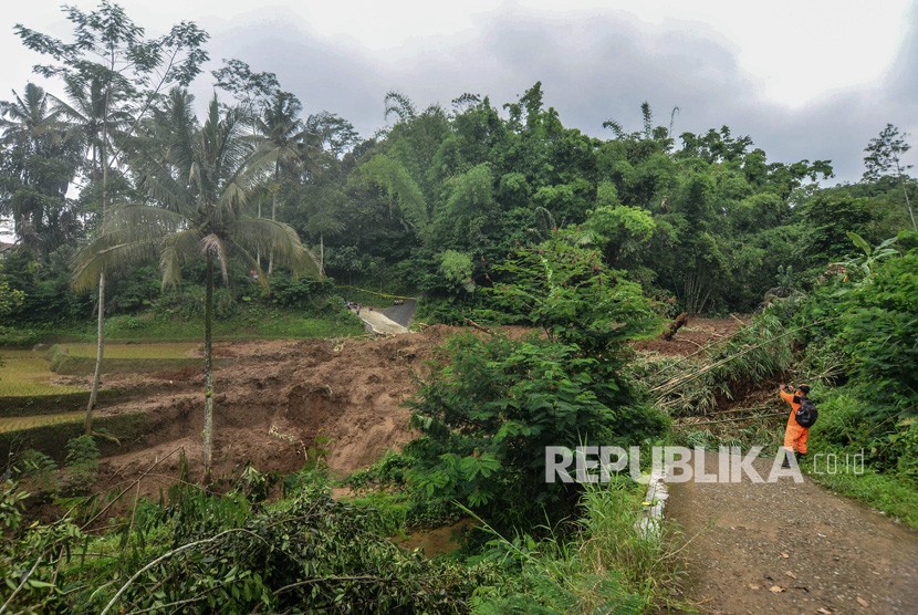 Warga melihat material tanah longsor yang menimbun jalan di Desa Santanamekar, Kecamatan Cisayong, Kabupaten Tasikmalaya, Jawa barat, Jumat (28/2/2020).