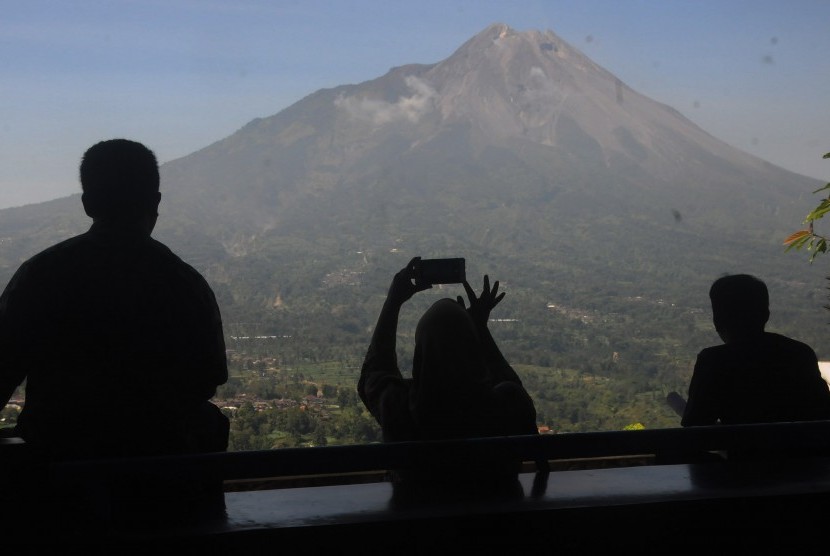 Warga melihat pemandangan Gunung Merapi di kawasan Magelang, Jawa Tengah, Kamis (20/6/2019).