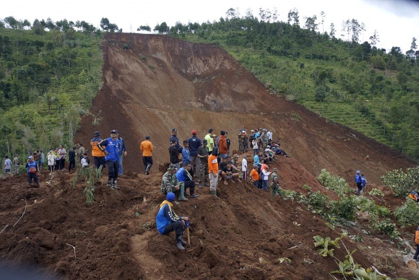 Warga melihat proses pencarian korban hilang tertimbun longsor di Desa Banaran, Ponorogo, Jawa Timur, Ahad (2/4). 