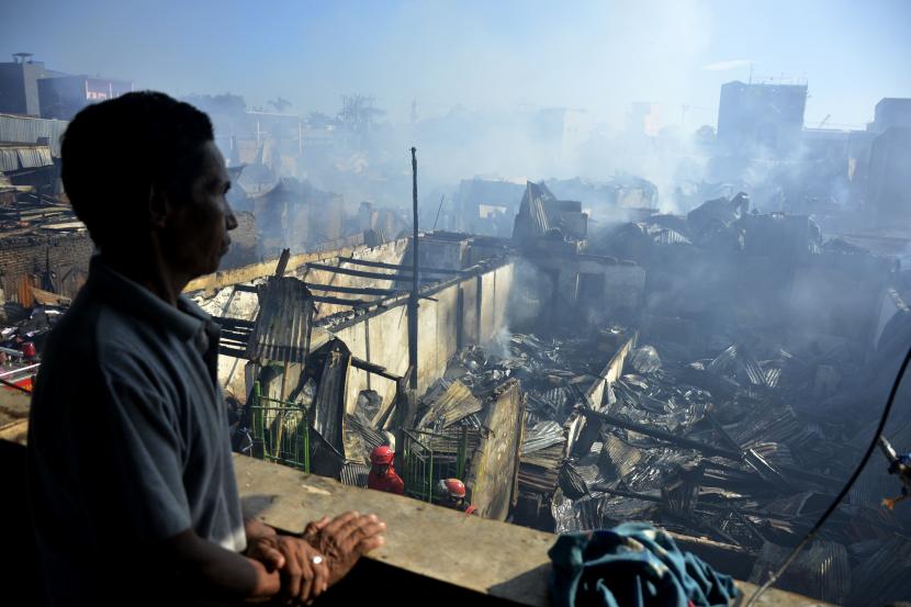 Warga melihat puing-puing rumah yang terbakar di kawasan Pasar Pannampu, Makassar, Sulawesi Selatan, Ahad (23/8/2020). Kebakaran yang terjadi di pemukiman padat penduduk tersebut menghanguskan puluhan unit rumah warga sementara penyebab kebakaran masih dalam penyelidikan kepolisian.