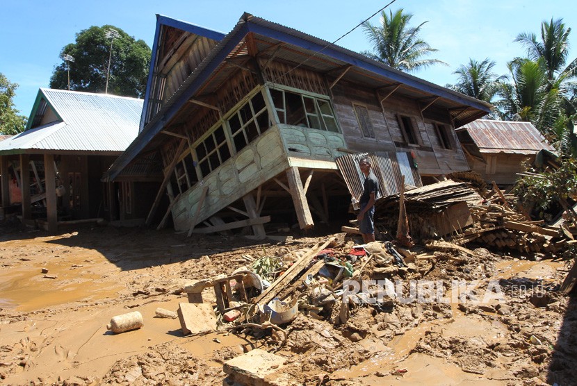 Warga melihat rumah yang ambruk karena diterjang banjir bandang (ilustrasi)
