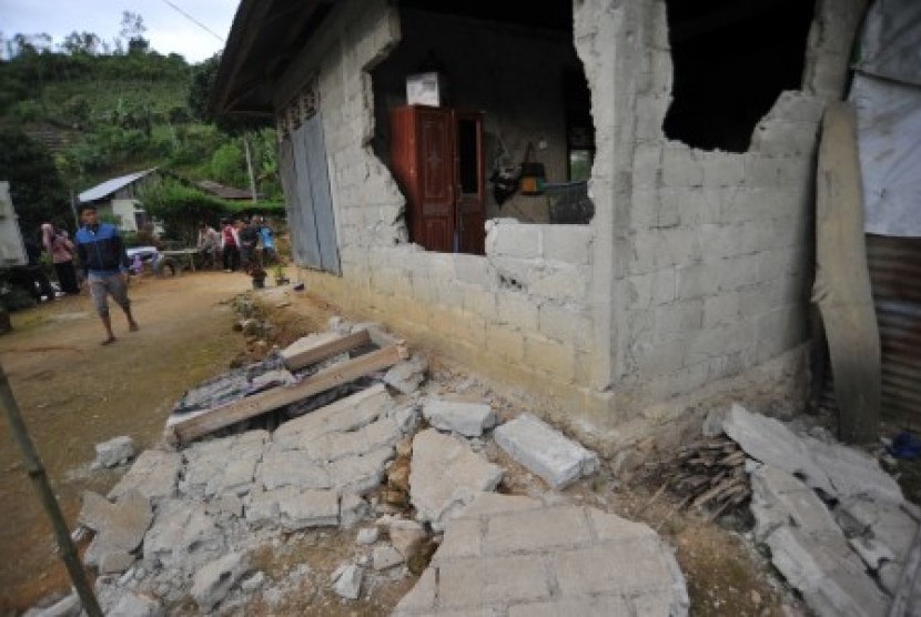 Warga melihat sebuah rumah yang rusak akibat gempa, di Jorong Lubuk Selasih, Nagari Batang Barus, Kec.Gunung Talang, Kab.Solok, Sumatra Barat, Sabtu (21/7). Gempa tektonik 5,5 Skala Richter mengakibatkan sejumlah rumah rusak berat dan retak serta menyebabkan seorang warga, Bustami (63) meninggal dunia karena tertimpa reruntuhan rumahnya. 