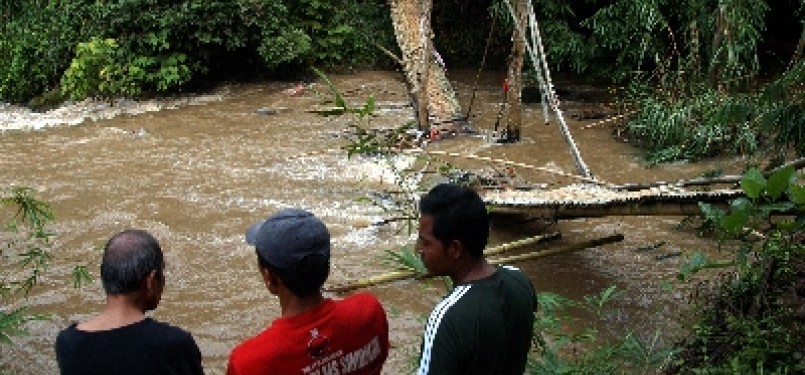 Warga melihat sisa jembatan runtuh di aliran sungai Cihideung, Cibanteng, Ciampea, Bogor, Jawa Barat. 