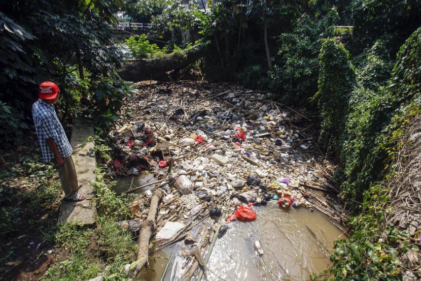 Warga melihat tumpukan sampah rumah tangga yang menyumbat aliran Sungai Kali Baru, Cibinong, Kabupaten Bogor, Jawa Barat, Rabu (14/9/2022). 