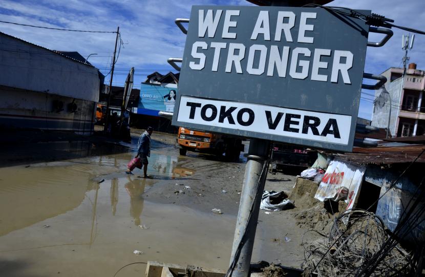 Warga melintas di area bekas banjir bandang di kecamatan Masamba, Kabupaten Luwu Utara, Sulawesi Selatan, Jumat (17/7/2020). Hingga hari ini, jumlah korban meninggal mencapai 32 orang sementara puluhan lainnya masih dalam pencarian.