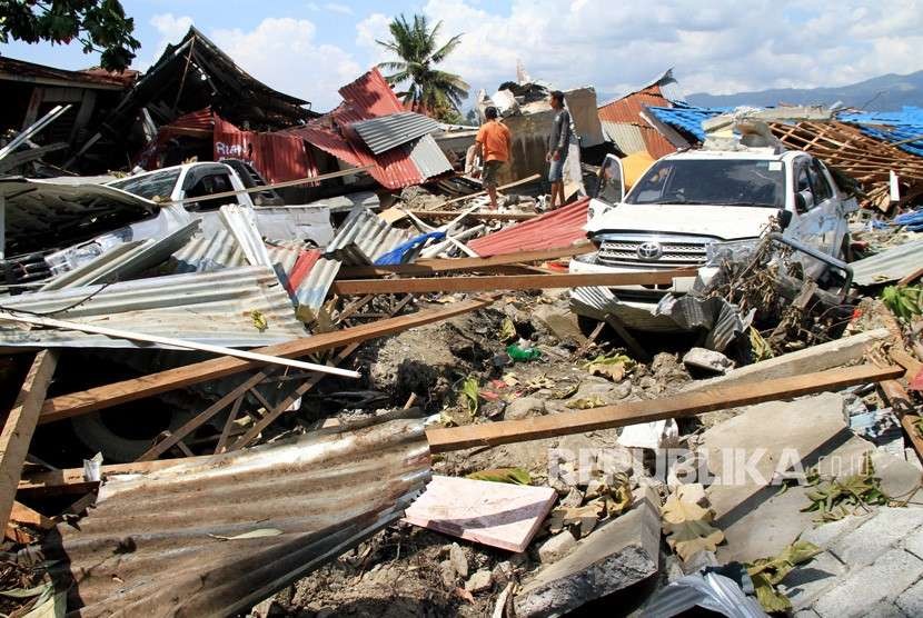 Warga melintas di area lokasi terkena gempa dan lumpur di Desa Sidera, Kabupaten Sigi, Sulawesi Tengah, Selasa (2/10).