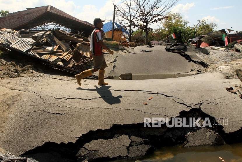 Warga melintas di area lokasi terkena gempa di Petabo, Palu Selatan, Sulawesi Tengah, Senin (1/10).