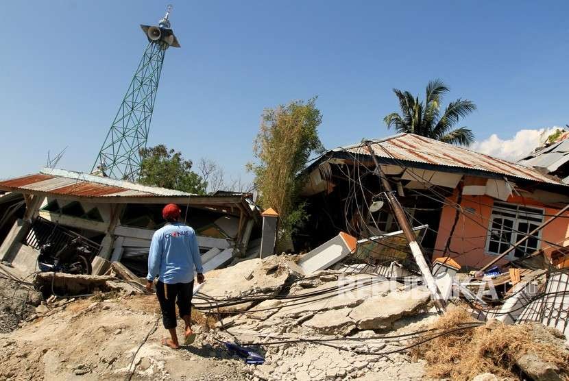 Warga melintas di area lokasi terkena gempa di Petabo, Palu Selatan, Sulawesi Tengah, Senin (1/10).