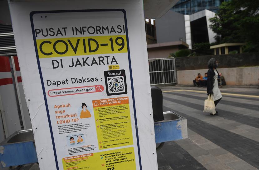 Warga melintas di dekat papan informasi COVID-19 di Jakarta, Senin (17/1/2022). Pemerintah akan menyesuaikan asesment level Pemberlakuan Pembatasan Kegiatan Masyarakat (PPKM) daerah dengan memasukkan indikator kepenuhan rawat inap di fasilitas kesehatan. 