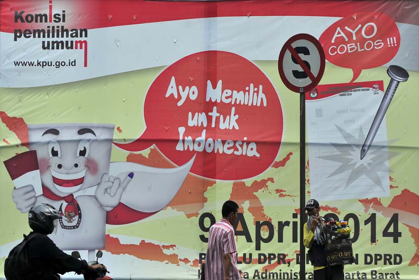  Warga melintas di depan baliho sosialisasi pemilu di Jakarta Barat, Rabu (15/1).