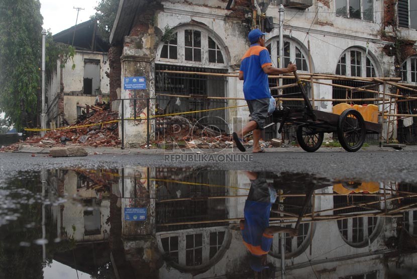 Warga melintas di depan bangunan tua yang ambruk di Kawasan Kota Tua, Jakarta Barat, Selasa (21/1).  (Republika/Rakhmawaty La'lang)