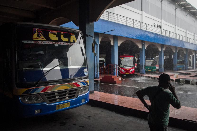 Warga melintas di depan bus yang parkir di Terminal Tirtonadi, Solo, Jawa Tengah
