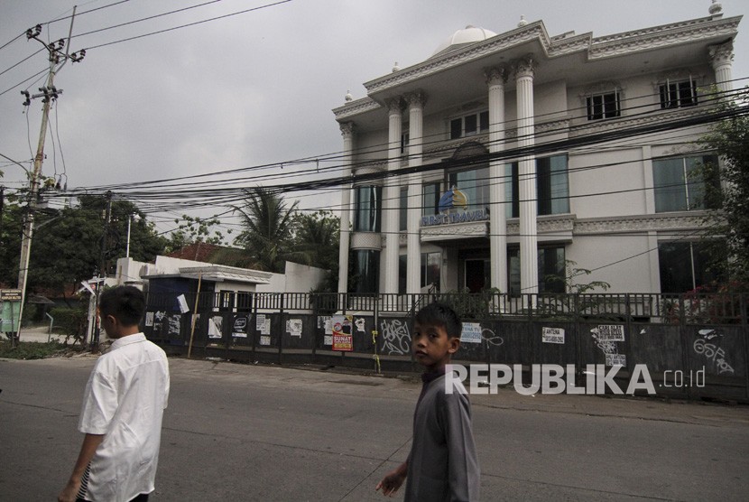 Warga melintas di depan Kantor First Travel Building atas nama Andika di jalan Radar Auri, Depok, Jawa Barat, Rabu (20/11/2019). 