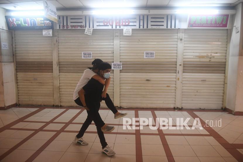 Warga melintas di depan kios-kios yang tutup saat penutupan Pasar Tanah Abang di Jakarta, Selasa (11/5/2021). Pasar Tanah Abang ditutup dalam rangka libur Lebaran hingga 18 Mei 2021. 