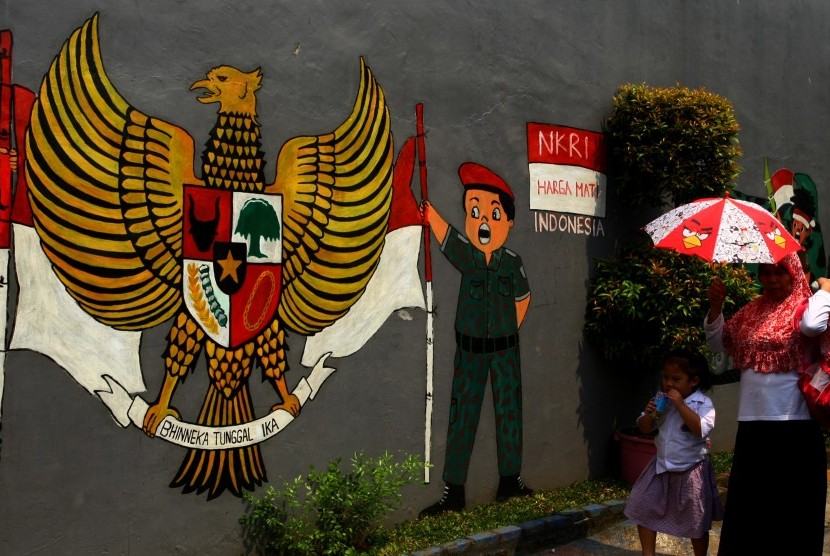 Kemiripan Sila Keempat Pancasila dengan Ungkapan Bahasa Arab. Warga melintas di depan mural bergambar Garuda Pancasila dan NKRI Harga Mati di kawasan Ciputat, Tangerang Selatan, Banten. (ilustrasi) 
