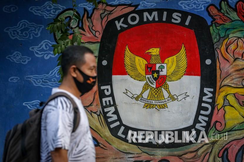 Warga melintas di depan mural bertema pemilihan umum di kawasan Pasar Anyar, Kota Tangerang, Banten, Kamis (7/5/2020). Presiden Joko Widodo menunda pemungutan suara Pemilihan Kepala Daerah (Pilkada) 2020 hingga Desember 2020 akibat wabah COVID-19.
