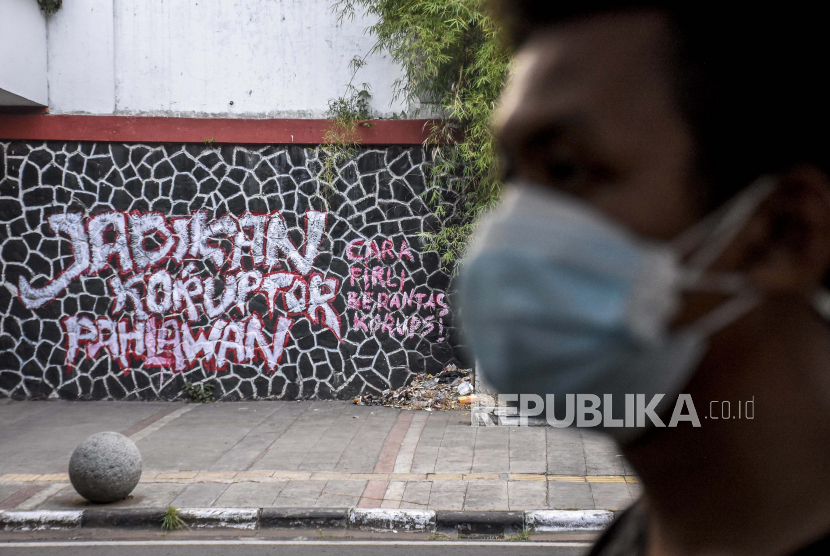 Warga melintas di depan mural yang bertuliskan Jadikan Koruptor Pahlawan di Jalan Perintis Kemerdekaan, Sumur Bandung, Kota Bandung, Senin (30/8). Mural tersebut merupakan bentuk ekspresi dari sejumlah seniman sekaligus media penyampaian kritik dan sindiran terhadap perilaku korupsi di Indonesia. 