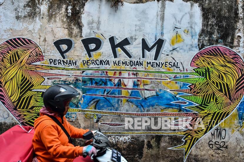 Warga melintas di depan sebuah mural di Kabupaten Ciamis, Jawa Barat, Rabu (25/8/2021). (Ilustrasi)