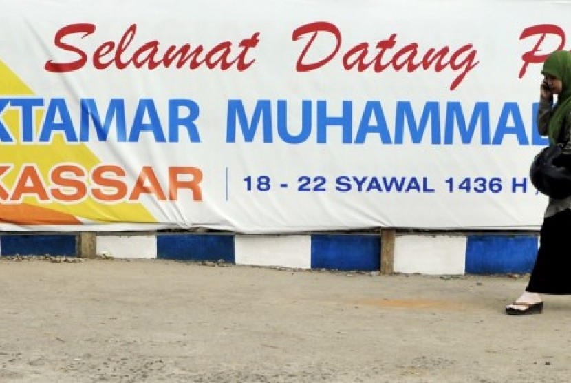 Warga melintas di depan spanduk penyambutan peserta Muktamar ke-47 Muhammadiyah di Kampus Universitas Muhammadiyah (Unismuh) Makassar, Sulawesi Selatan, Ahad  (26/7). 