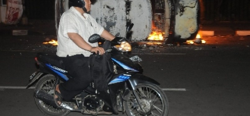 Warga Melintas di di Jalan Kimia, Salemba, Jakarta Pusat, Kamis malam (29/3) setelah pecah kerusuhan dalam unjuk rasa penolakan kenaikan harga bahan bakarf minyak (BBM) oleh mahasiswa UPI YAI dan UKI