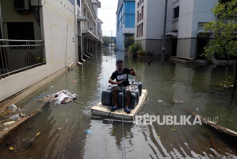   Warga melintas di genangan banjir rob di kawasan pasar ikan Pelabuhan Muara Baru, Penjaringan, Jakarta Utara, Rabu (8/6). (Republika/Yasin Habibi)