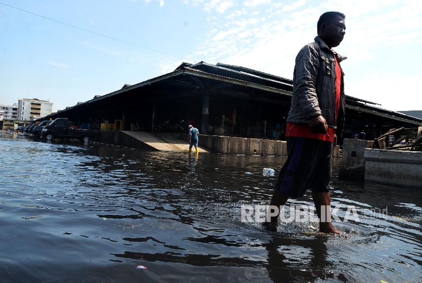 Warga melintas di genangan banjir rob di kawasan pasar ikan Pelabuhan Muara Baru, Penjaringan, Jakarta Utara, Rabu (8/6).  (Republika/Yasin Habibi)