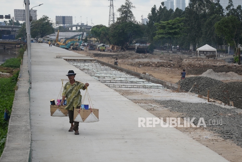 Warga melintas di Jalan Inspeksi yang sedang dalam proses pelebaran dan ditinggikan di kawasan Kalijodo, Jakarta Utara, Rabu (6/4). (Republika/ Yasin Habibi )