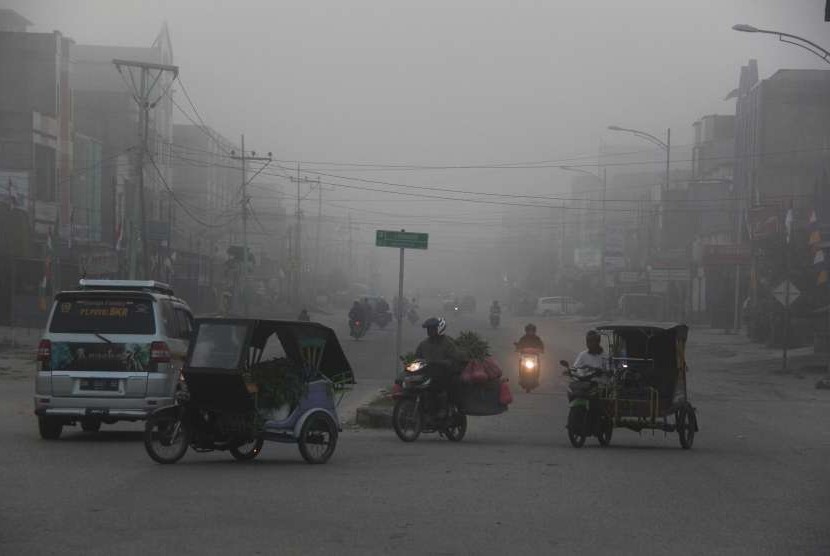 [ilustrasi] Warga melintas di jalan yang diselimuti kabut asap di kota Dumai, Dumai, Riau, Kamis (16/8).