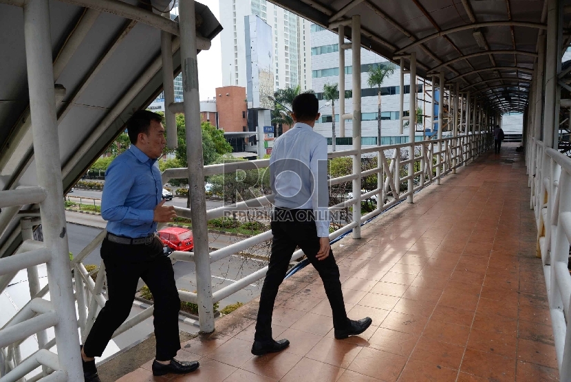 Warga melintas di Jembatan Penyeberangan Orang (JPO) di Jalan Rasuna Said, Jakarta, Kamis (26/11). 