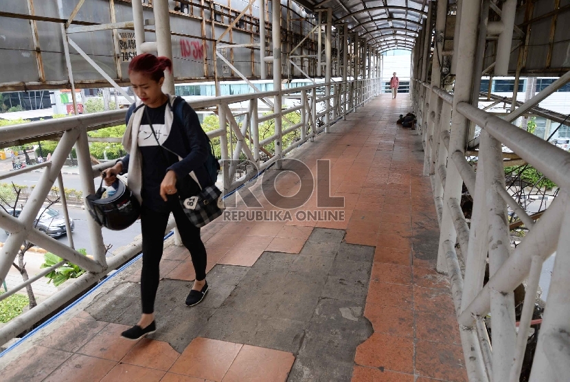 Warga melintas di Jembatan Penyeberangan Orang (JPO) di Jalan Rasuna Said, Jakarta, Kamis (26/11).