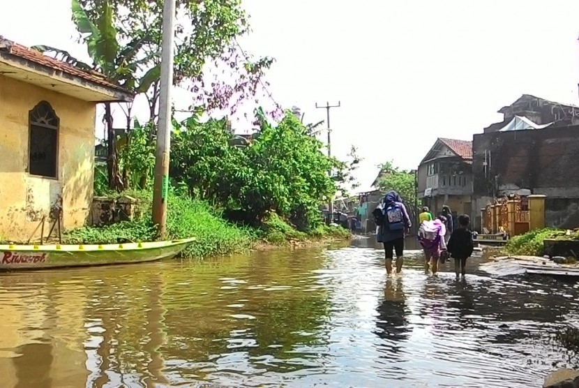 warga melintas di Kampung Cieunteung, Kecamatan Baleendah, Kabupaten Bandung, Kamis (26/11)