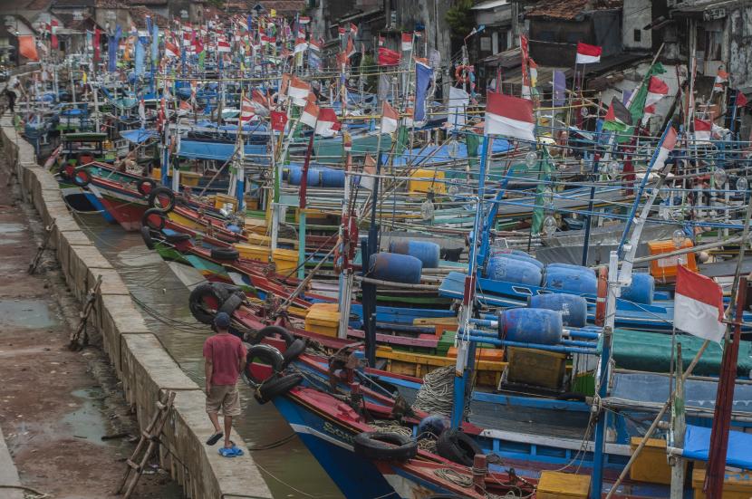 Warga melintas di kapal nelayan yang bersandar saat tidak melaut. Kabupaten Aceh Selatan menargetkan produksi ikan tangkap di kabupaten di pesisir pantai barat Provinsi Aceh tersebut mencapai 32.577 ton pada 2022.