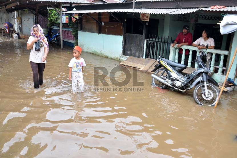 Warga melintas di kawasan pemukiman yang terendam banjir di Kampung Keramat, Condet, Jakarta Timur, Senin (8/10). (Rakhmawaty La'lang)