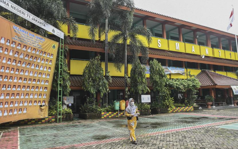 Warga melintas di lapangan sekolah SMAN 71, Duren Sawit, Jakarta Timur, Rabu (12/1/2022). Pembelajaran Tatap Muka (PTM) 100 persen di sekolah tersebut diberhentikan sementara selama lima hari sampai Jumat (14/1/2022) setelah seorang siswa yang positif COVID-19.