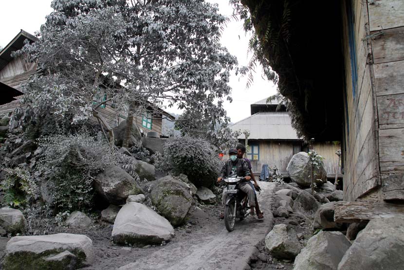   Warga melintas di pemukiman yang diselimuti debu vulkanik gunung Sinabung di Desa Mardingding, Karo, Sumut, Selasa (5/11).  (Antara/Rony Muharrman)