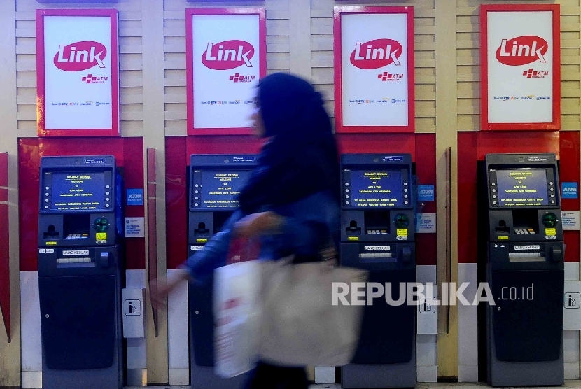  Warga melintas didekat mesin ATM Himpunan Bank-Bank Milik Ngara (Himbara) di Pasar Tanah Abang, Jakarta, Ahad (9/10).