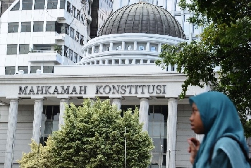 Warga melintas didepan gedung Mahkamah Konstitusi (MK), Jakarta, Ahad (11/1).