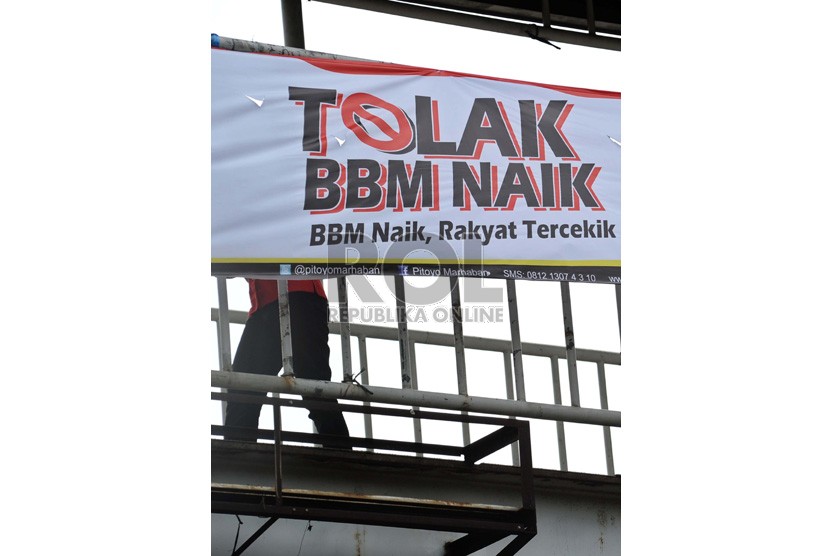 Warga melintas didepan spanduk penolakan kenaikan BBM di Jakarta, Jumat (7/6).  (Republika/Tahta Aidilla)