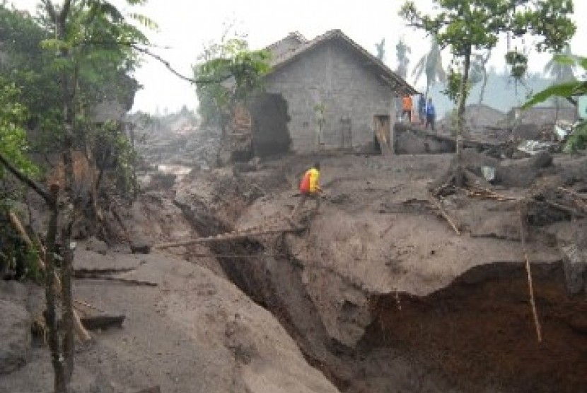 Warga melintas jembatan darurat diatas aliran baru sungai yang terbentuk akibat terjangan lahar hujan di Dusun Gempol, Jumoyo, Salam, Magelang, Selasa (4/1). Belum ada laporan korban jiwa dalam bencana yang menghantam perumahan penduduk.