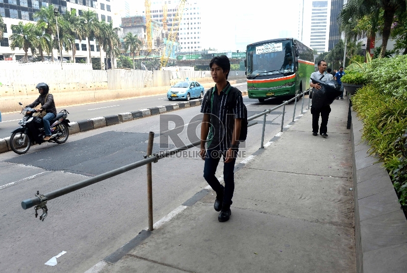 Warga melintas menggunakan trotoar di kawasan Jalan Sudirman, Jakarta Pusat, Jumat (20/11).