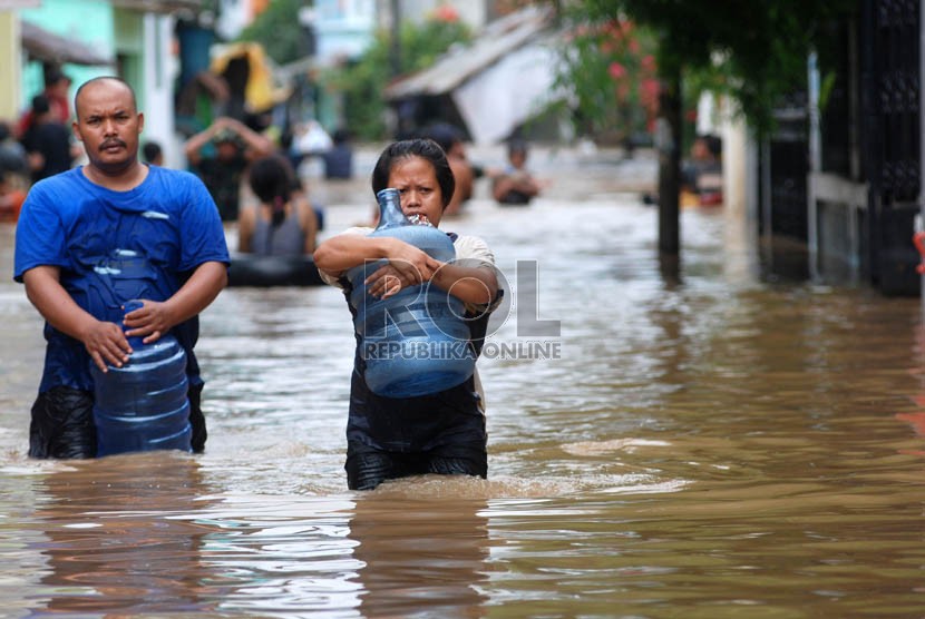   Warga melintas saat banjir merendam rumah mereka di Kampung Poncol