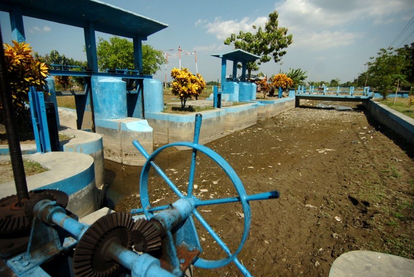 Warga melintas samping pintu air Wangan Bui yang kekeringan di Desa Pemaron, Brebes, Jawa Tengah, Selasa (18/6/2019).