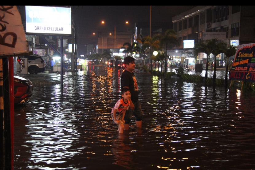 Warga melintasi banjir besar pasang air laut (rob) yang cukup mengganggu aktivitas warga (ilustrasi)