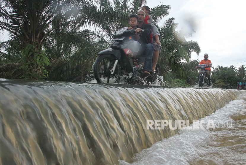 Warga melintasi banjir di Aceh Timur, Aceh