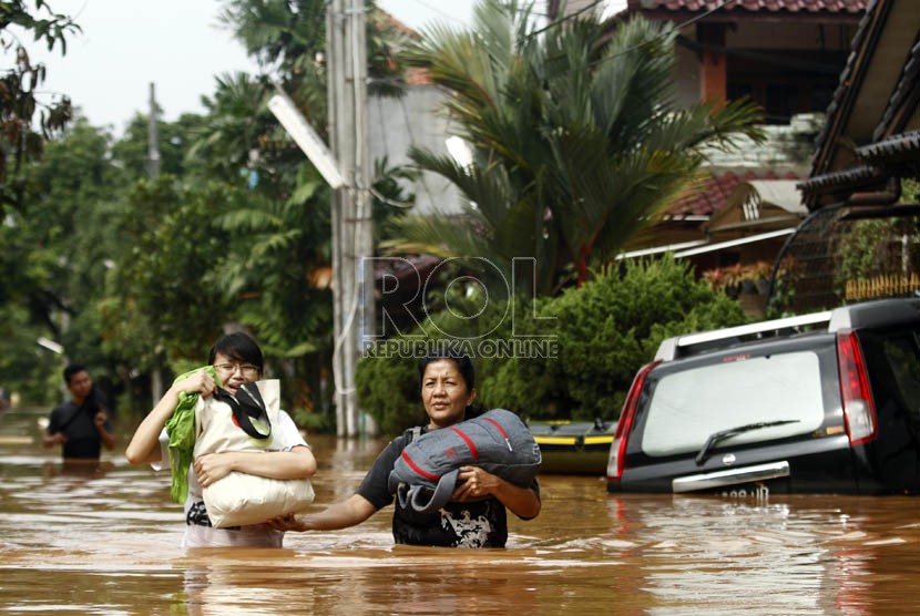   Warga melintasi banjir di Perumahan Bumi Nasio Indah, Jatiasih, Bekasi, Jawa Barat, Kamis (18/4).  