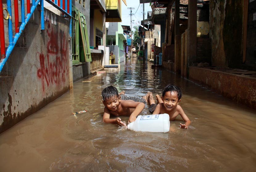 Warga melintasi banjir kiriman saat melanda kawasan Kampung Pulo, Jakarta Timur, Selasa (5/8). (Republika/ Yasin Habibi).