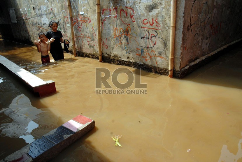  Warga melintasi banjir yang menggenangi kawasan Kampung Melayu Kecil 1, Poncol, Bukit Duri, Jakarta Selatan,Senin (22/10).   (Agung Fatma Putra)